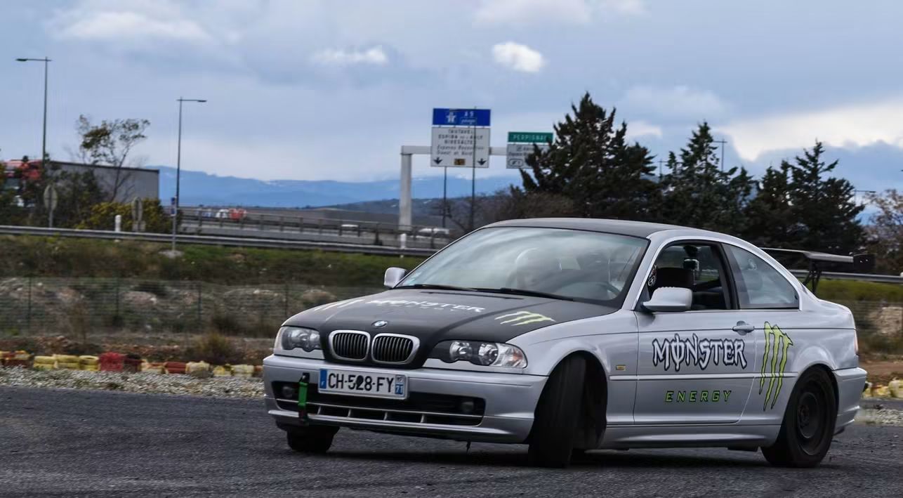 Une BMW Série 3 argentée sur circuit, lors des premières années de pratique.